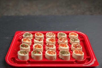 cheese platter. Mazzarella cheese with different spices. Cheese snacks of different taste in a plastic container or tray, background or banner on the theme of food and snacks
