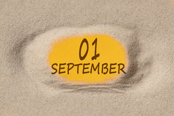 September 1. 1th day of the month, calendar date. Hole in sand. Yellow background is visible through hole. Autumn month, day of the year concept