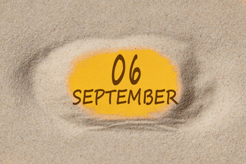 September 6. 6th day of the month, calendar date. Hole in sand. Yellow background is visible through hole. Autumn month, day of the year concept