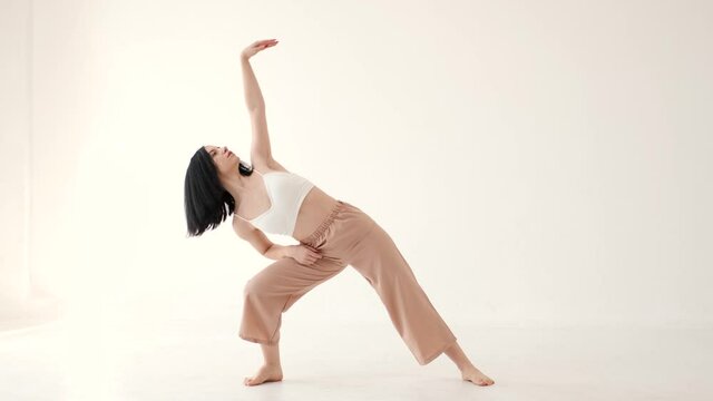 Woman in beige costume dancing contemp on white background