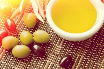 Containers and bowls with virgin olive oil and olives.