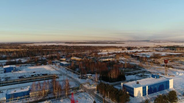Large territory of wastewater treatment plant with electricity production substation in winter evening aerial view