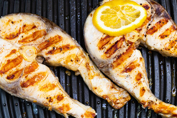 Grilled  fish in grill pan with lemon