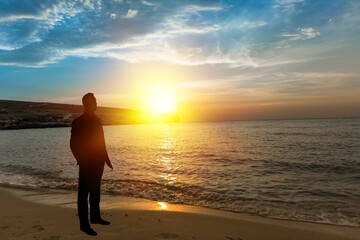 Fototapeta premium Man relaxing on the beautiful beach at sunset.