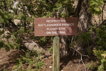 Warning sign - Respect the rattlesnakes privacy - please stay on the trail, warning hikers of...