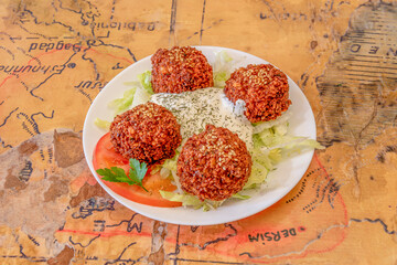 Homemade falafel balls accompanied by yogurt and salads made in a Turkish restaurant