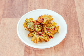 Portion of artichoke flowers sautéed with diced Iberian ham placed in a home delivery container