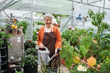 Florist is caring of the flowers while pouring water and touching to it with love