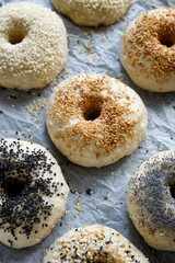 Raw bagels with the addition of various seeds prepared for baking, top view