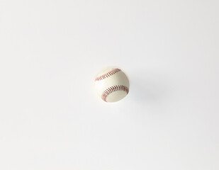 white baseball with red strings on a white background