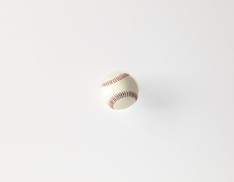 white baseball with red strings on a white background