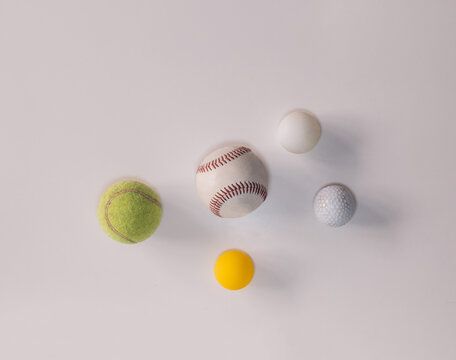 different balls for different sports such as baseball, tennis, ping pong, frontenis and golf on white background with copy space.