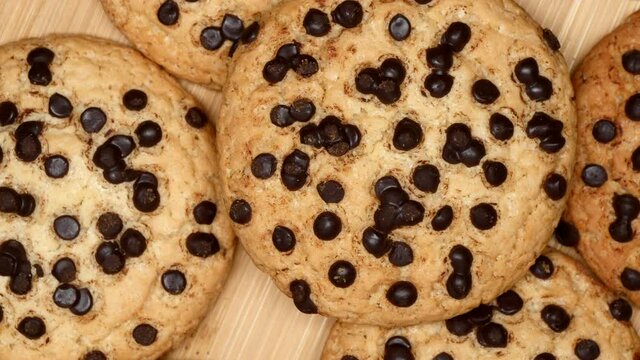 Rotating Fresh Brown Oatmeal Cookies With Chocolate On Wooden Board And Gray Background. Top View. Close Up.