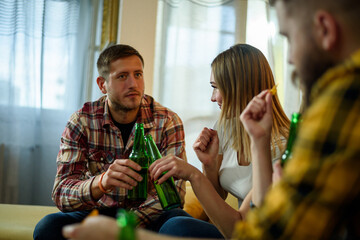 Friends on a house party hanging out together and drinking beer