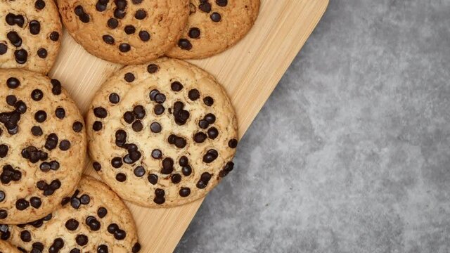 Rotating Fresh Brown Oatmeal Cookies With Chocolate On Wooden Board And Gray Background On The Left Side. Top View. Close Up.
