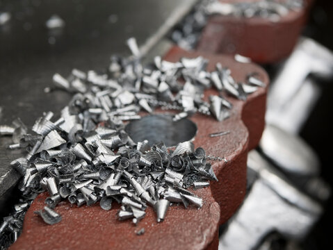 Metal shavings on the surface of lathe, close up. Turned metal particles