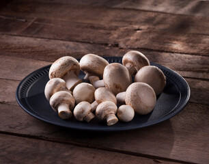 some paris mushrooms in plate on a rustic wooden table