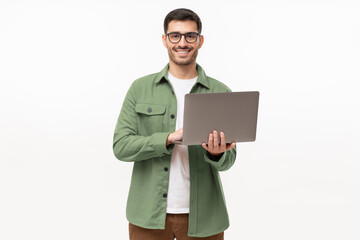 Young man standing in casual green shirt, holding laptop and looking at camera with happy smile,...