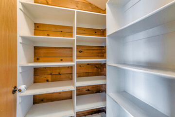 White wooden shelves and racks in the pantry or wardrobe room