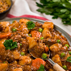 Beef Curry Stew with Potatoes and Carrots on Wooden Background. Selective focus.