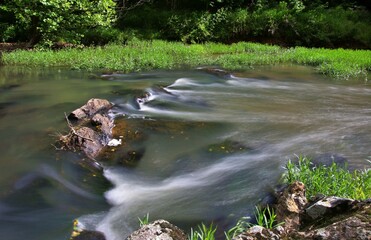Long exposure of water flowing over rocks in a river.  Intentional motion blur of the water. 