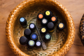 mall glasses of essential oils in straw bowl top view