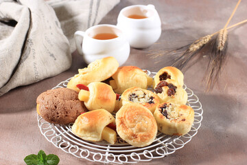 Assorted One Bites Mini Bread or Popular as Roti Unyil Venus on White Plate, White Background. Served for Accompanied Tea. Copy Space for Text