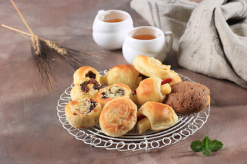 Assorted One Bites Mini Bread or Popular as Roti Unyil Venus on White Plate, White Background. Served for Accompanied Tea. Copy Space for Text