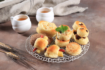 Naklejka na ściany i meble Assorted One Bites Mini Bread or Popular as Roti Unyil Venus on White Plate, White Background. Served for Accompanied Tea. Copy Space for Text