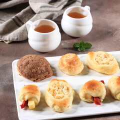 Assorted One Bites Mini Bread or Popular as Roti Unyil Venus on White Plate, White Background. Served for Accompanied Tea. Copy Space for Text