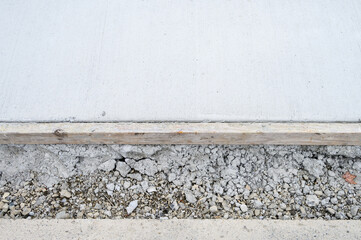 Freshly poured concreate sidewalk, closeup of concrete, wood form, and overspill
