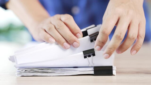 Asian Businessman hands working in stacks of paper files document management desk office