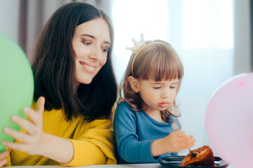 Mother Watching Little Toddler Girl Eating Cake for her Anniversary