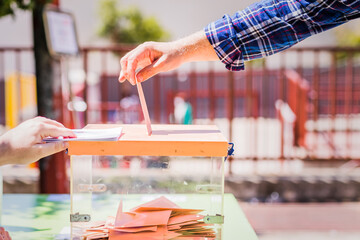 Autonomous community of Madrid elections. Democraty referendum for government vote. Hand posing an envelop in a ballot box for community elections - obrazy, fototapety, plakaty