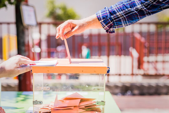 Autonomous community of Madrid elections. Democraty referendum for government vote. Hand posing an envelop in a ballot box for community elections