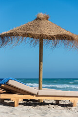 Fototapeta premium Deck chairs and straw umbrellas on the wonderful island of Formentera in Spain