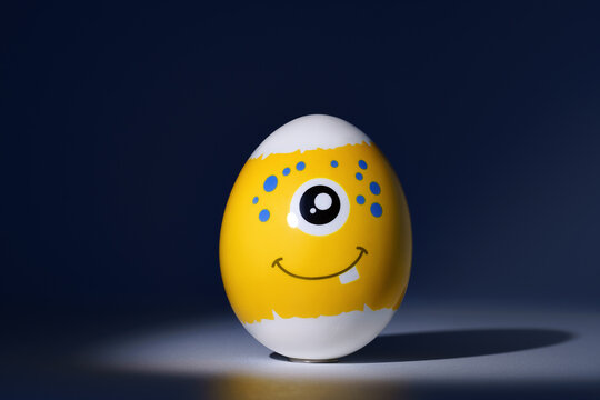 Yellow festive easter egg with one-eyed emoticon