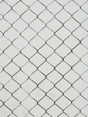 old wire mesh of fence with white metal wall background