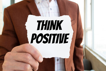 THINK POSITIVE, message on the card shown by a man