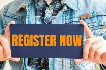 REGISTER NOW, message on the card shown by a man