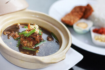 The black beef soup is an Indonesian traditional food served with buffalo meat and salted eggs, smeared with black sauce and very tasty