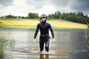 A scuba diver in a wet suit prepares
