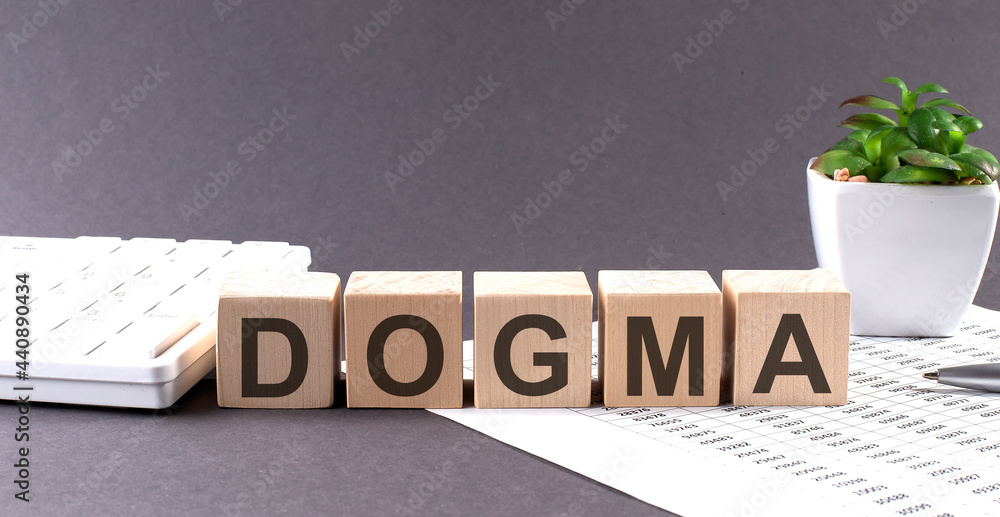 Poster dogma text on the wooden block with notebooks ,keyboard on chart