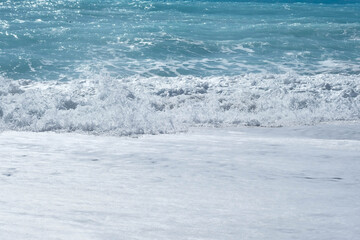 Blue waves roll onto the sandy shore