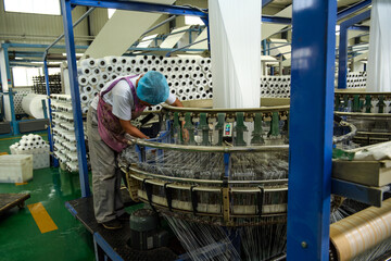 A packaging plant of woven bag workshop machinery is running, workers in the busy work.