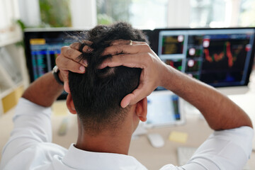 Stock trader tearing out his hair in frustration after loosing money of his clients