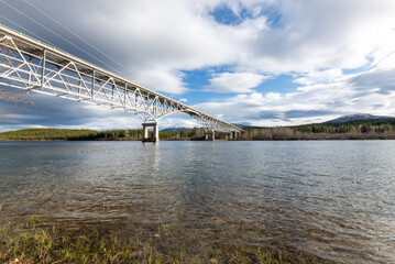 Johnsons Crossing Bridge over Teslin River in northern Canada during spring, summer time with steel beams running above and blue sunset sky along the Alaska Highway, Yukon Territory.