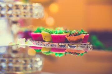 Fototapeta na wymiar Colourful mini cupcakes on a decorative glass tray