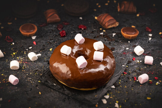 Chocolate glazed doughnut decotrated with marshmallows
