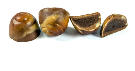 Candy with dark chocolate cream filling on a white background
